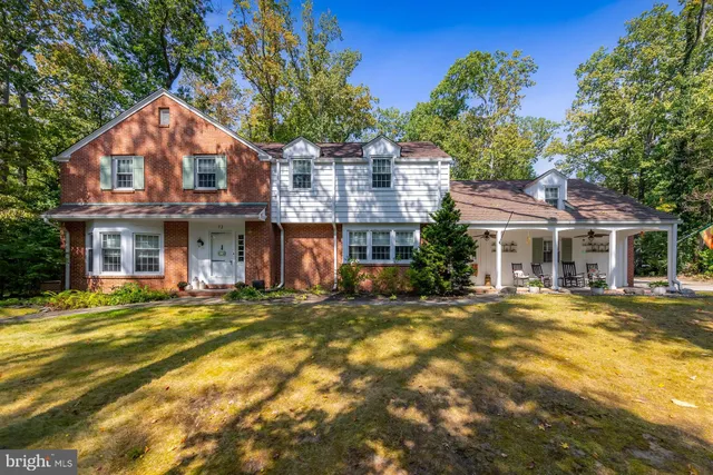 a view of a large building with a large pool and lawn chairs under an umbrella