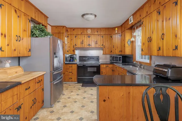 a kitchen with stainless steel appliances kitchen island granite countertop a stove a sink and a microwave