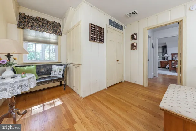 a bedroom with a bed and a dresser next to a window