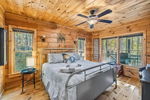 a bedroom with a bed and wooden floor