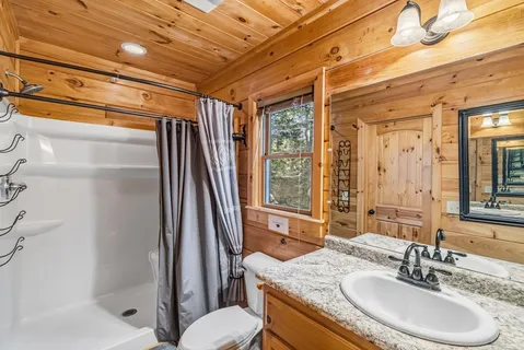 a bathroom with a granite countertop sink toilet and shower