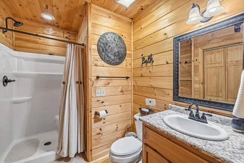 a bathroom with a granite countertop sink toilet and shower
