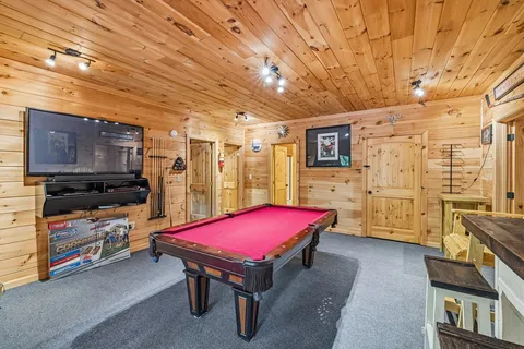 a room with furniture pool table and flat screen tv