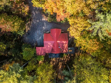 an aerial view of a house with a yard and a large tree