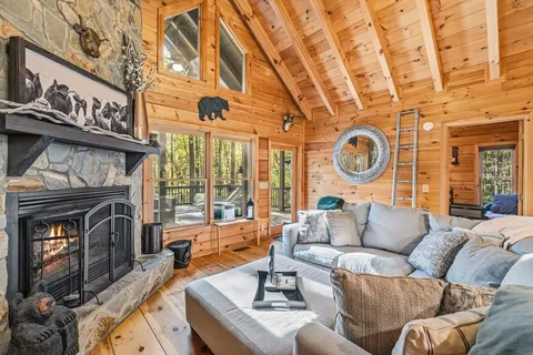 a living room with furniture a fireplace and a large window