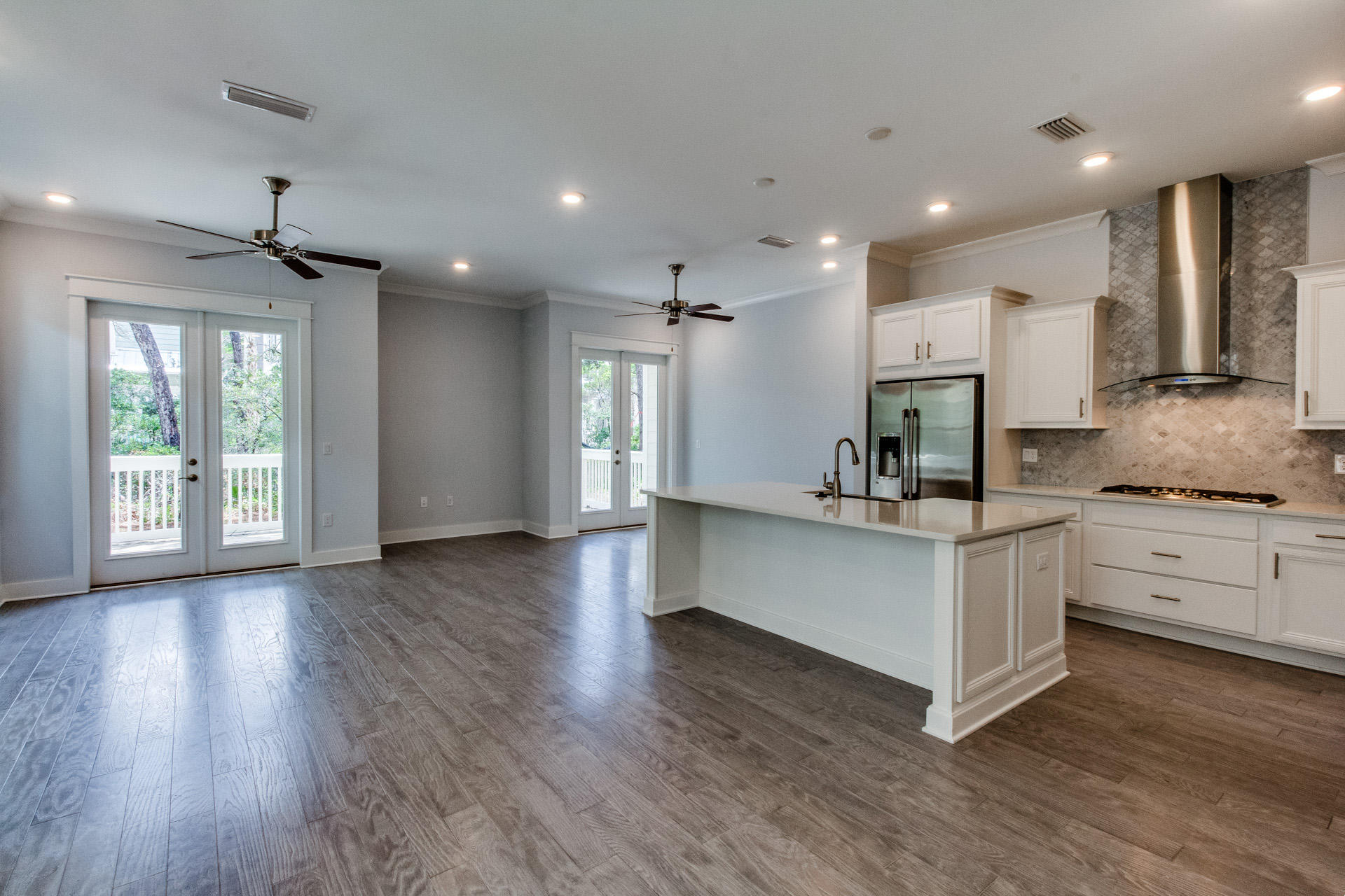 146 Pine Lands Loop Inlet Beach East, Unit A Inlet Beach, FL 32461 - Photo 26 of 42 a kitchen with stainless steel appliances granite countertop a stove a sink and white cabinets with wooden floor