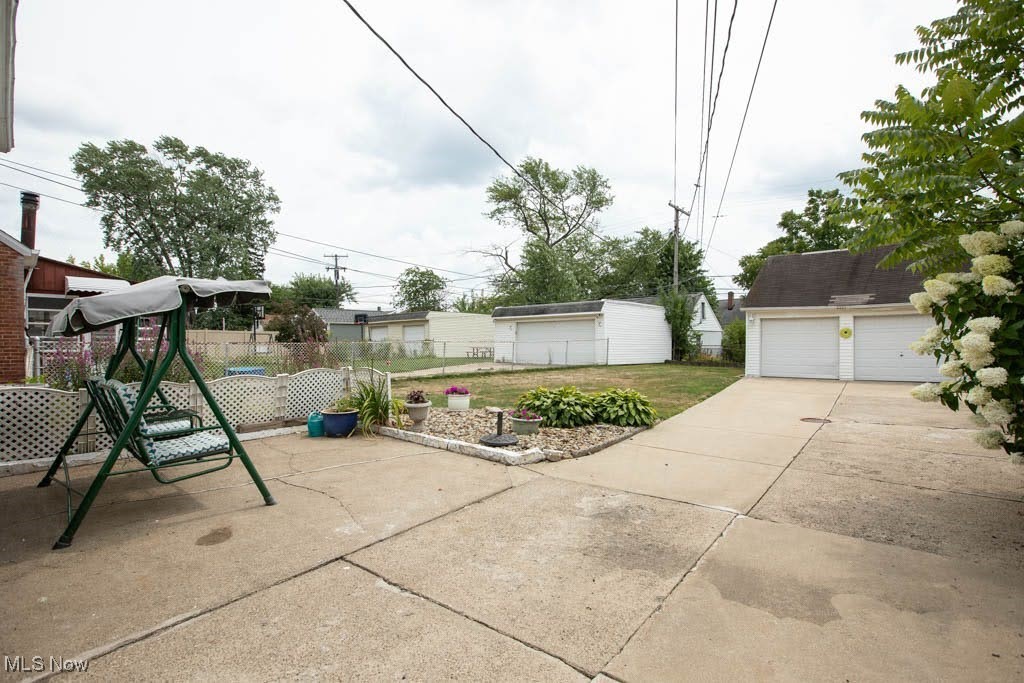 12822 Grannis Road Cleveland, OH 44125 - Photo 37 of 44 View of patio / terrace featuring an outdoor structure, a garage, and a playground