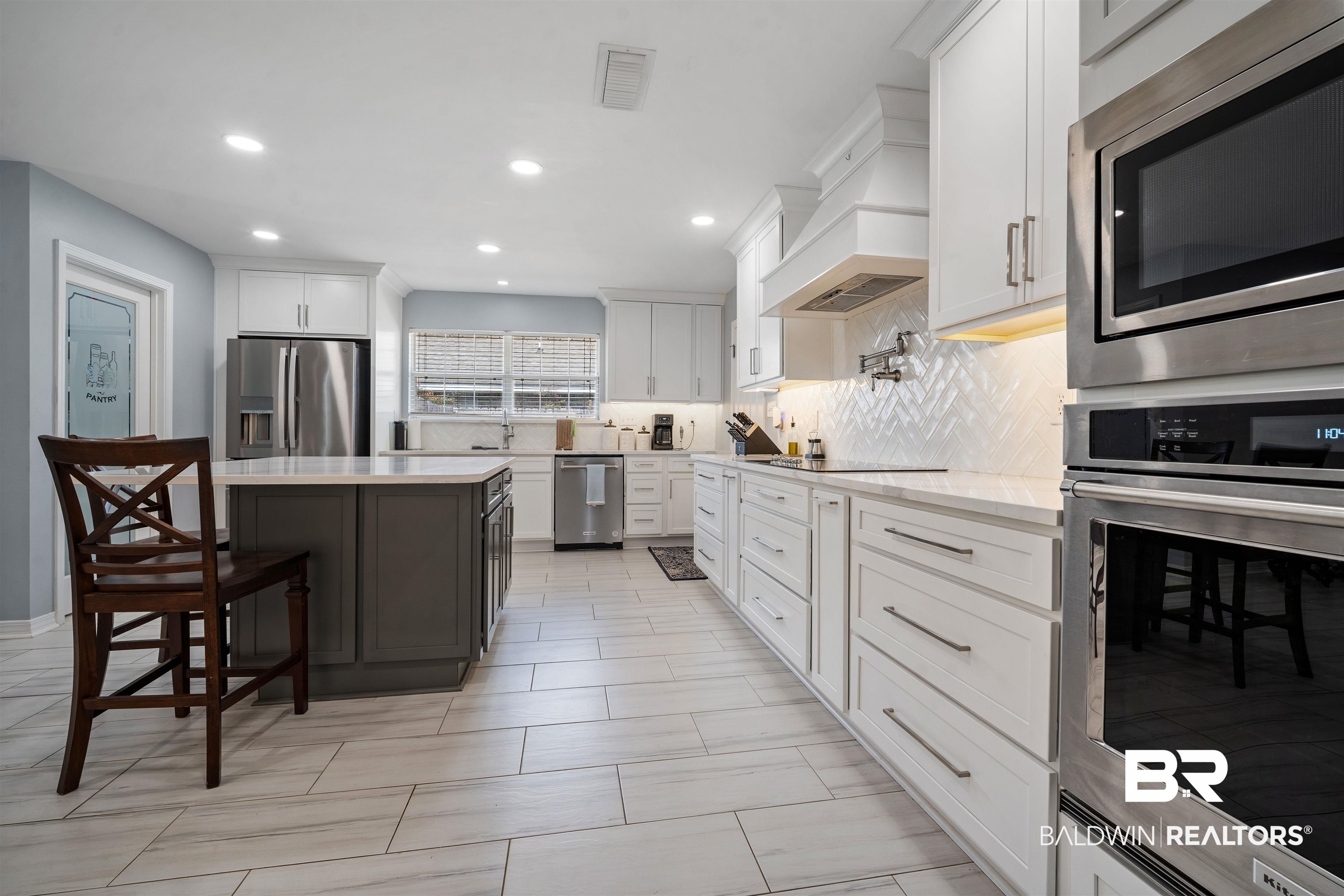 10713 Rigby Drive Mobile, AL 36695 - Photo 7 of 35 Kitchen with stainless steel appliances, dual tone cabinets, recessed lighting, tasteful backsplash, and light stone counters