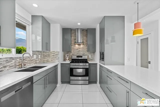 a kitchen with stainless steel appliances granite countertop a sink and a stove