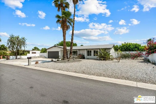 a front view of a house with a yard and garden