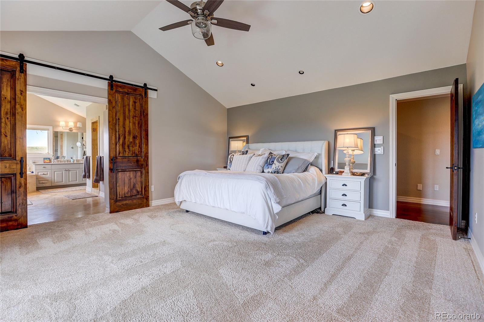 147 Commander Drive Erie, CO 80516 - Photo 18 of 50 a spacious bedroom with a bed and a chandelier