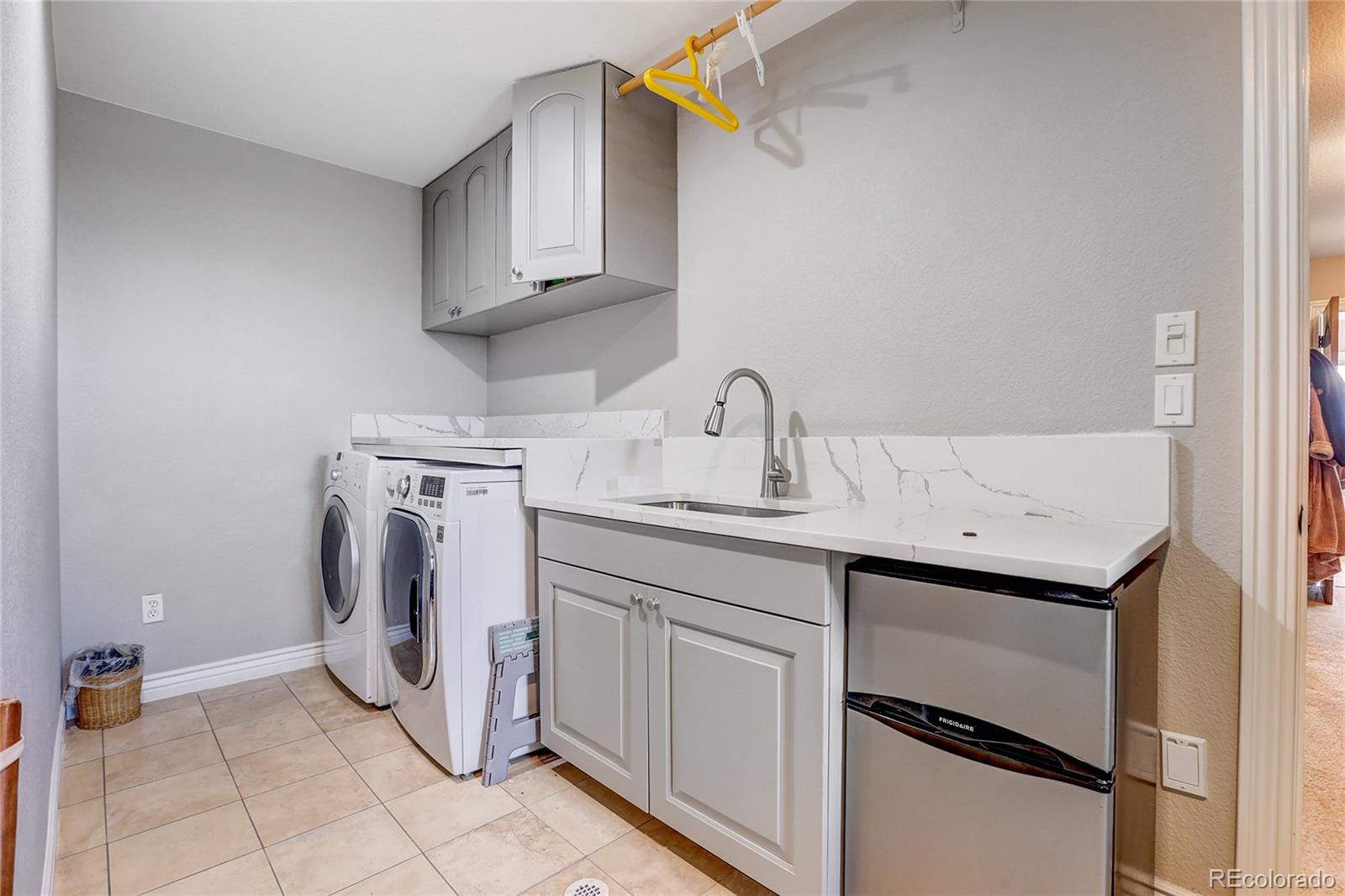 147 Commander Drive Erie, CO 80516 - Photo 26 of 50 a utility room with sink dryer and washer