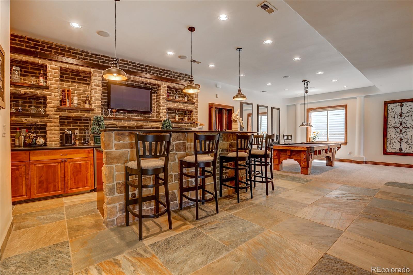 147 Commander Drive Erie, CO 80516 - Photo 27 of 50 a open kitchen with lots of wooden furniture a dining table and chairs