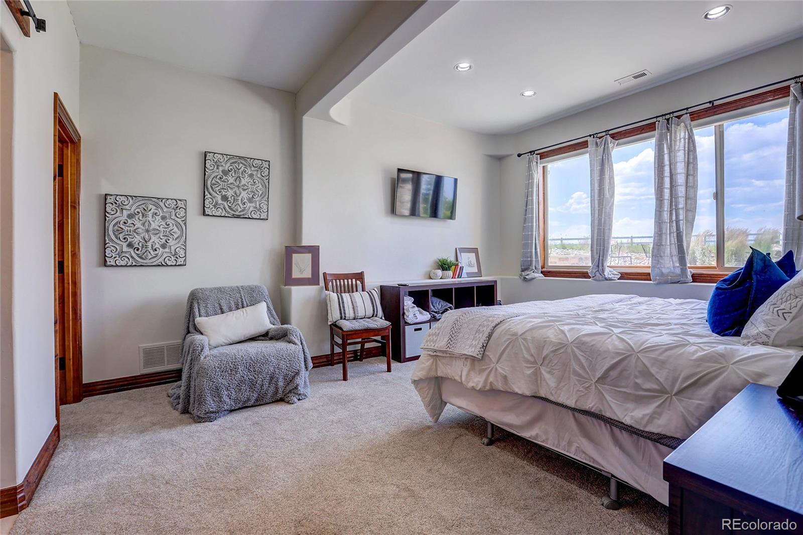 147 Commander Drive Erie, CO 80516 - Photo 31 of 50 a spacious bedroom with a bed and a couch
