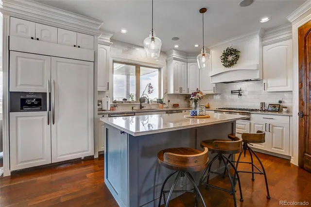 a open kitchen with stainless steel appliances granite countertop a stove oven and a refrigerator with cabinets
