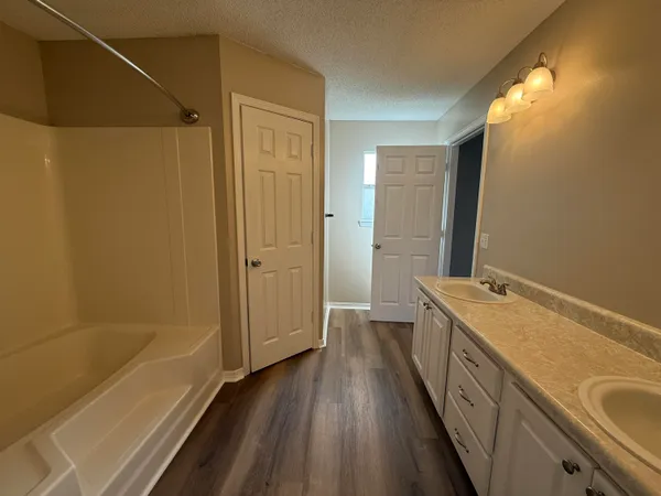 a bathroom with a tub sink and mirror