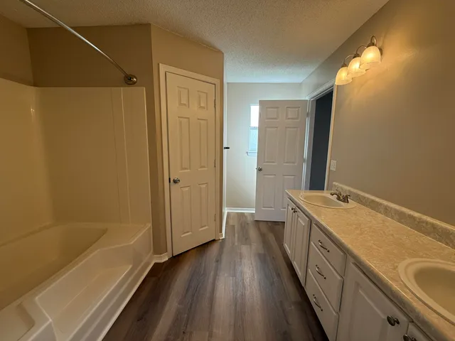 a bathroom with a tub sink and mirror
