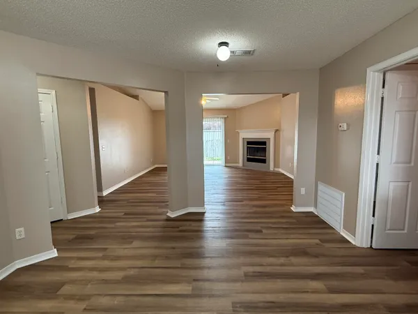 a view of a hallway with wooden floor fireplace and living room