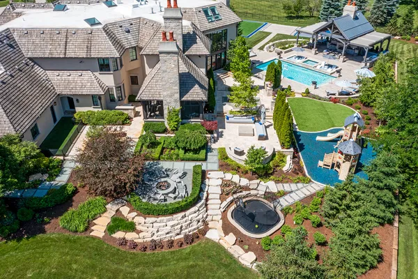 an aerial view of a house with swimming pool and outdoor seating