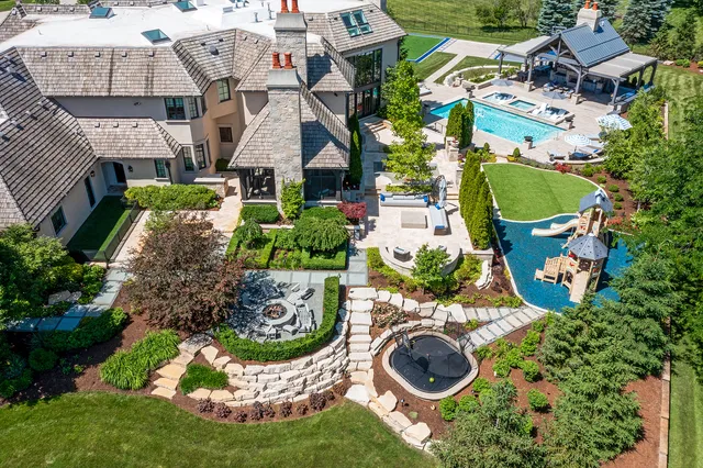 an aerial view of a house with swimming pool and outdoor seating