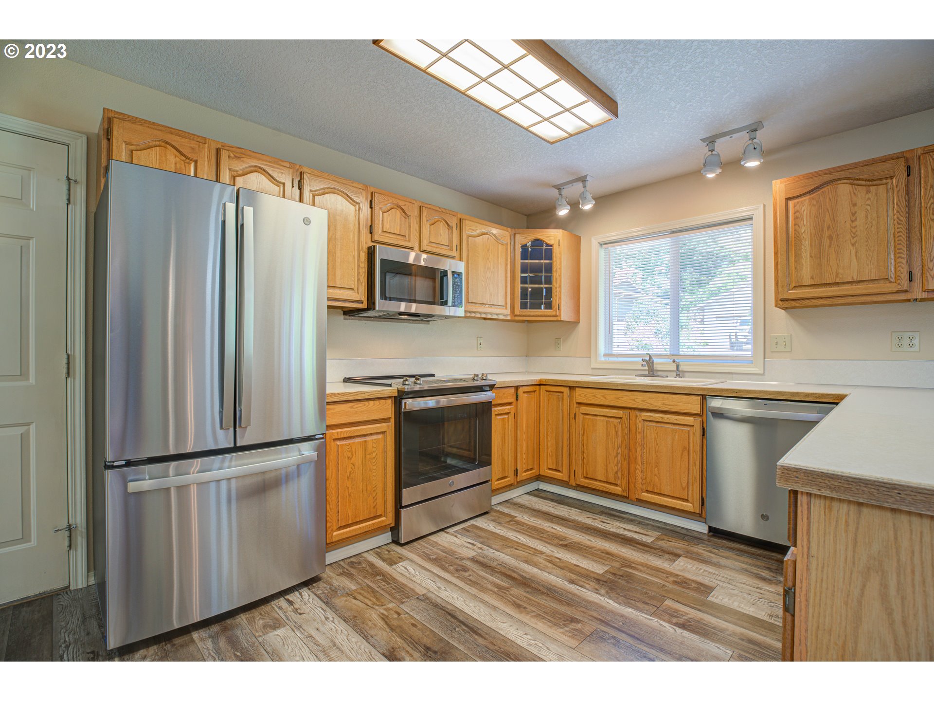 4523 Southeast Hill Road Milwaukie, OR 97267 - Photo 9 of 48 a kitchen with stainless steel appliances granite countertop a refrigerator a sink dishwasher a stove a refrigerator and microwave