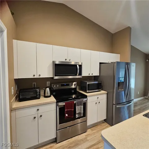 a kitchen with stainless steel appliances a stove microwave and refrigerator