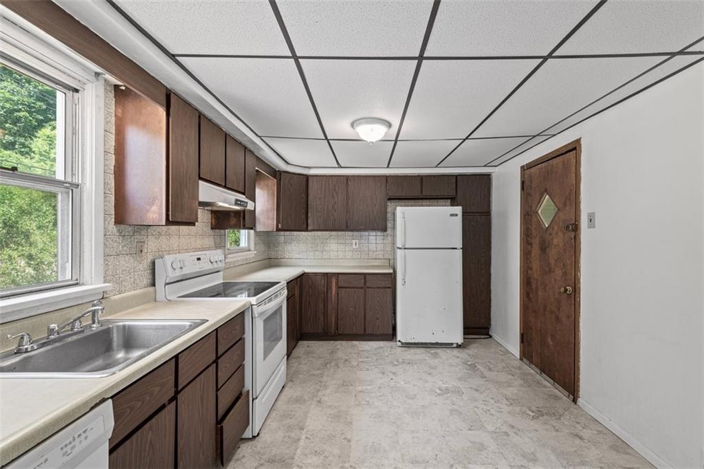 1012 Universal Road Pittsburgh, PA 15235 - Photo 4 of 13 a kitchen with stainless steel appliances granite countertop a sink a stove a refrigerator cabinets and a window