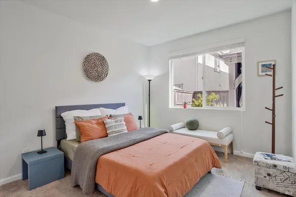 a bedroom with a bed and a painting on the wall