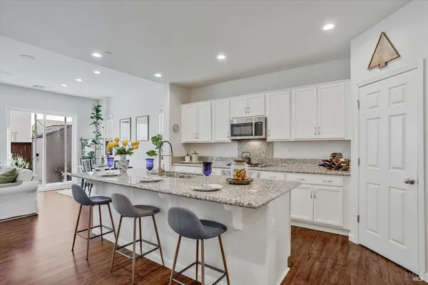 a kitchen with stainless steel appliances granite countertop a sink and a microwave