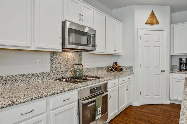 a living room with furniture and a dining table with wooden floor