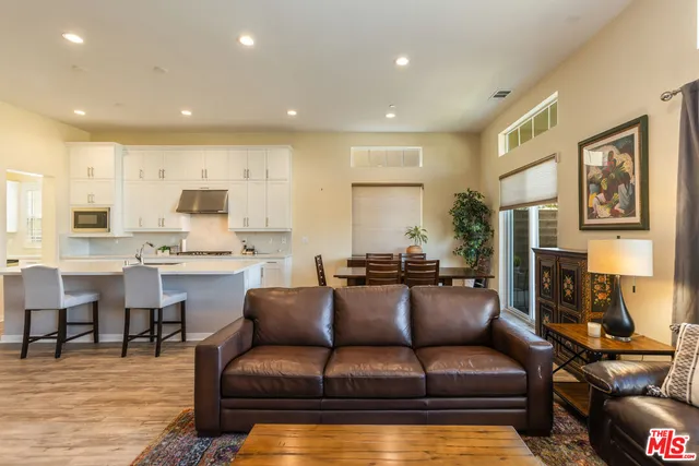 a view of living room kitchen with stainless steel appliances granite countertop furniture and a couch