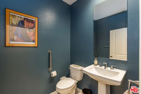 a bathroom with a toilet a sink and mirror