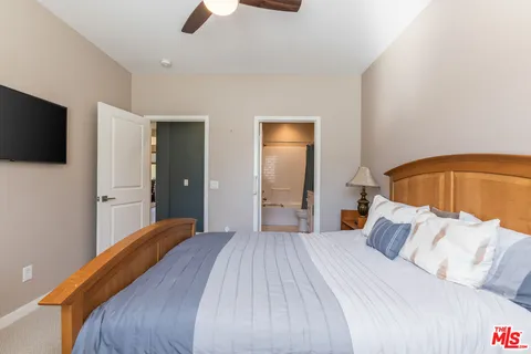 a bedroom with a large bed and a flat screen tv