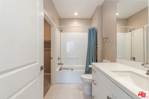 a bathroom with a granite countertop sink a toilet and shower