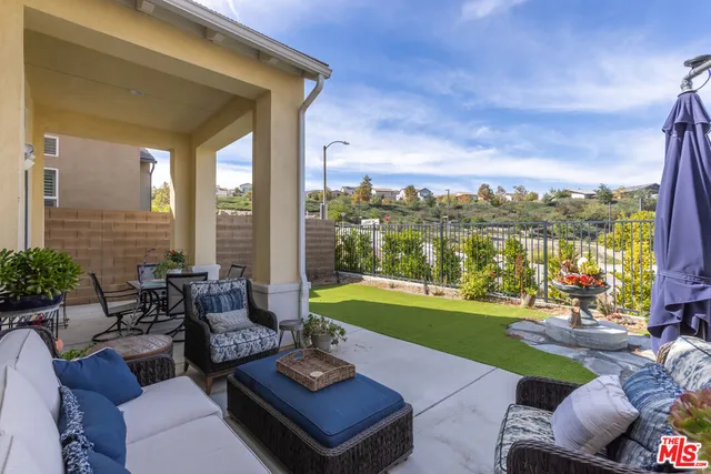 a view of a patio with couches chairs and a big yard