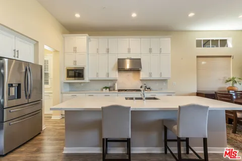 a kitchen with a sink stainless steel appliances and white cabinets