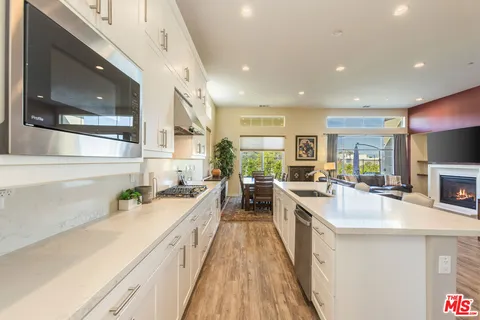 a large kitchen with stainless steel appliances lots of counter space and wooden floor