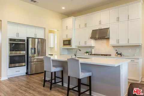 a kitchen with stainless steel appliances a stove a sink refrigerator and a cabinets