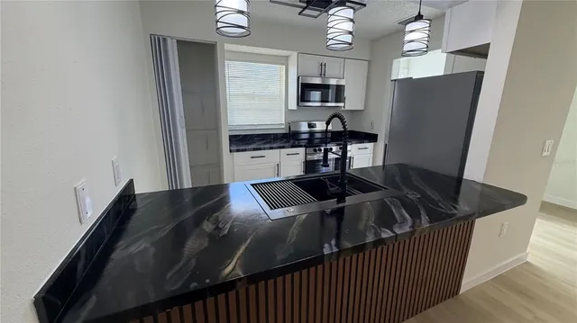 a kitchen with a kitchen island a stove and a refrigerator