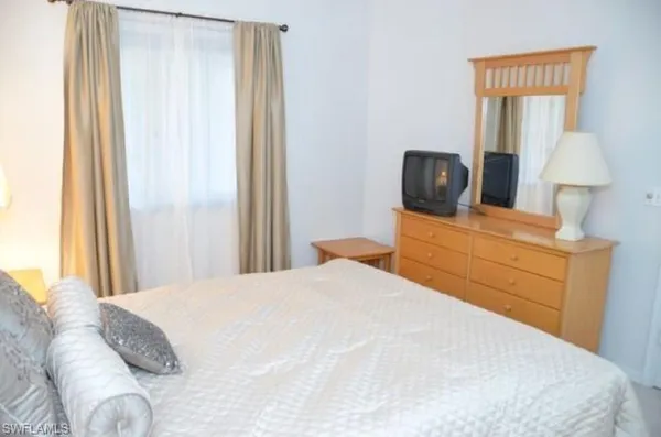 a bedroom with a bed and a mirror