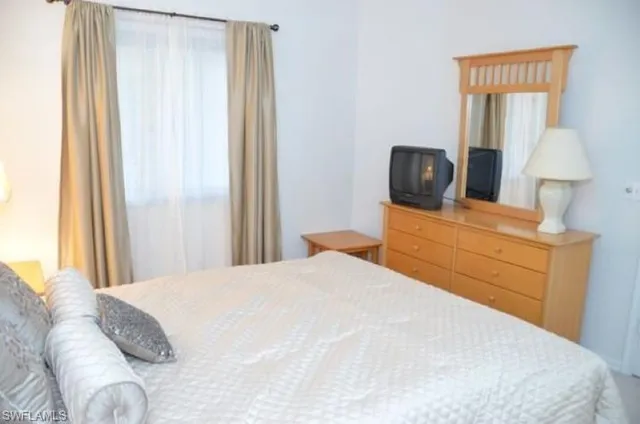 a bedroom with a bed and a mirror