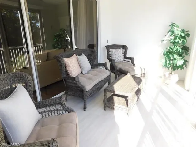 a living room with furniture a fireplace and a floor to ceiling window