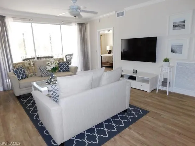a view of a hallway with wooden floor windows and a bathroom