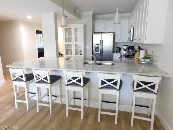 a kitchen with stainless steel appliances granite countertop a dining table chairs and granite counter tops