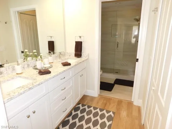 a bathroom with a double vanity sink mirror and bathtub