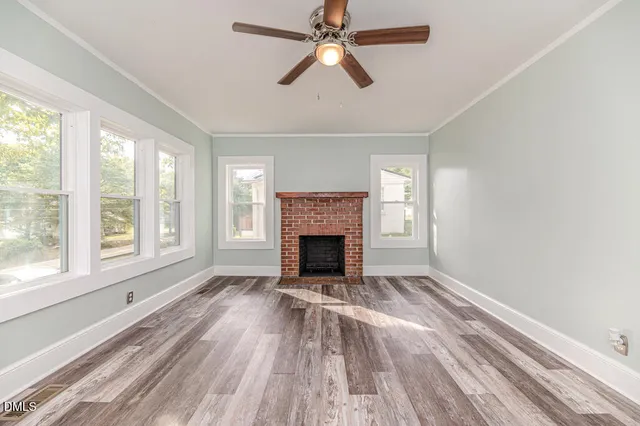 wooden floor fireplace and windows in an empty room
