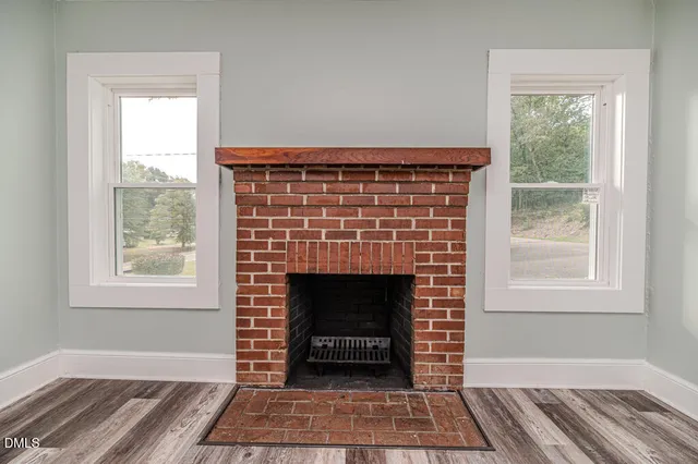 a living room with a fireplace and windows