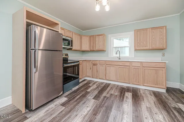 a kitchen with granite countertop stainless steel appliances a refrigerator sink and cabinets