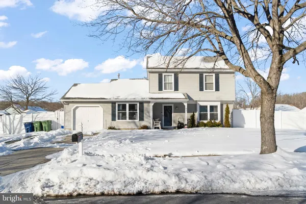 a front view of a house with a yard covered with snow