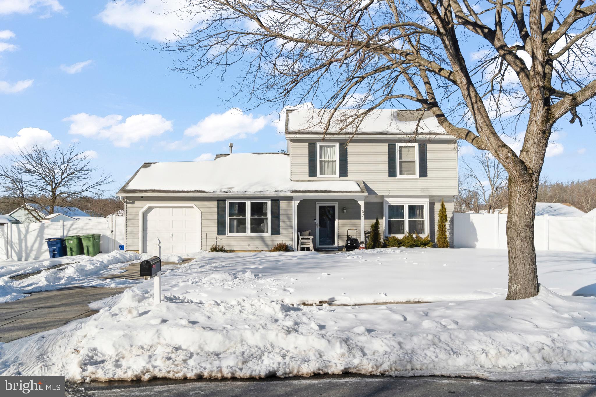 a front view of a house with a yard covered with snow